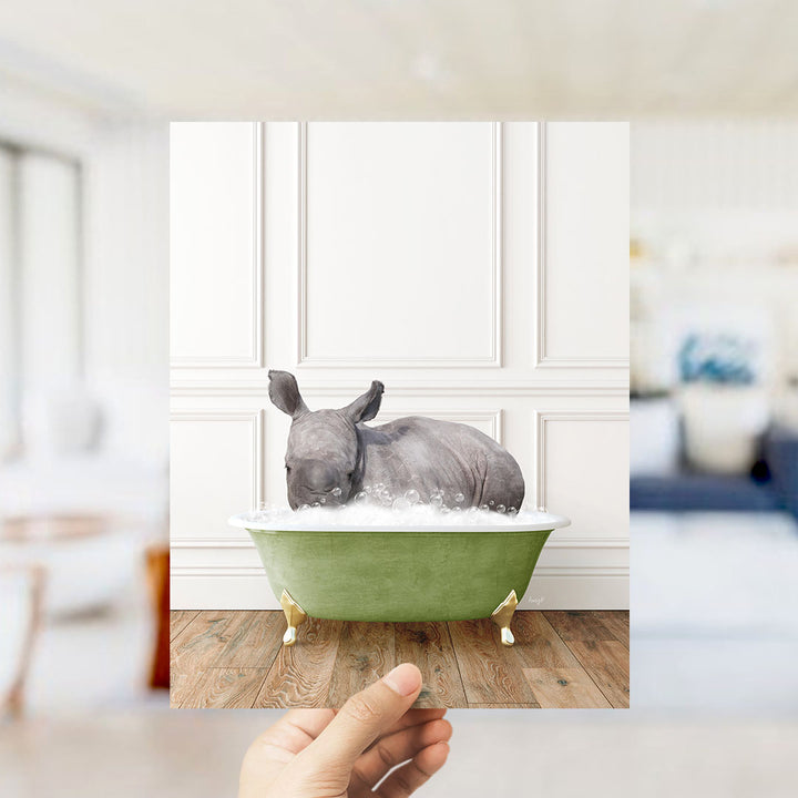 A rhinoceros is sitting in a green bathtub filled with bubbles, creating a whimsical and playful scene.