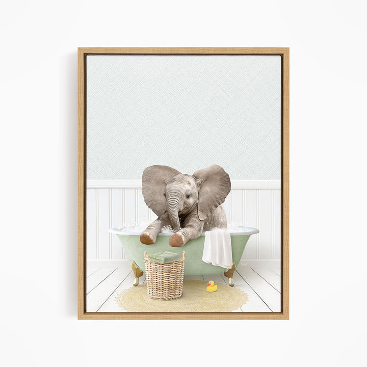 A baby elephant sitting in a green bathtub, surrounded by a basket of toys and a yellow rubber duck.