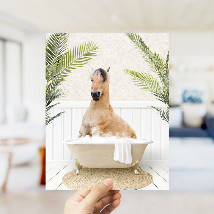 A light brown horse is sitting in a white bathtub filled with bubbles, surrounded by green palm leaves, creating a whimsical and relaxing scene.