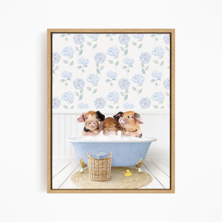 Three adorable pigs sitting in a blue bathtub, surrounded by a wicker basket and rubber duckies, with a floral patterned wall behind them.