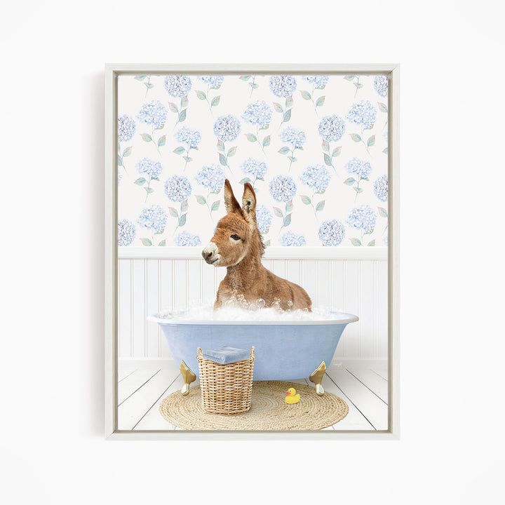 A donkey is sitting in a blue bathtub filled with water, surrounded by a wicker basket and a yellow rubber duck.