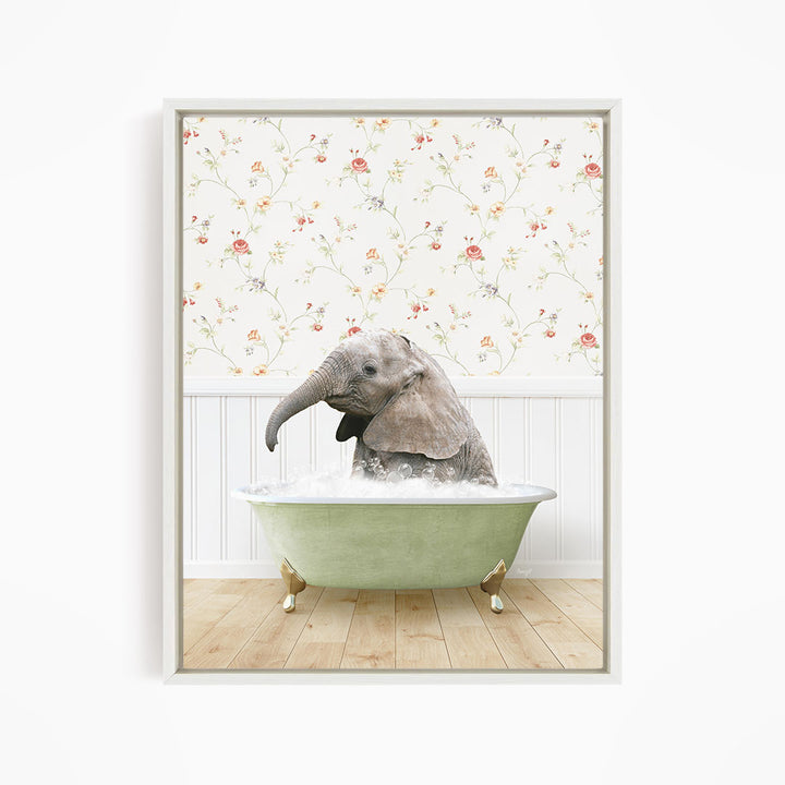 A baby elephant sitting in a green bathtub filled with water, surrounded by a floral wallpaper.