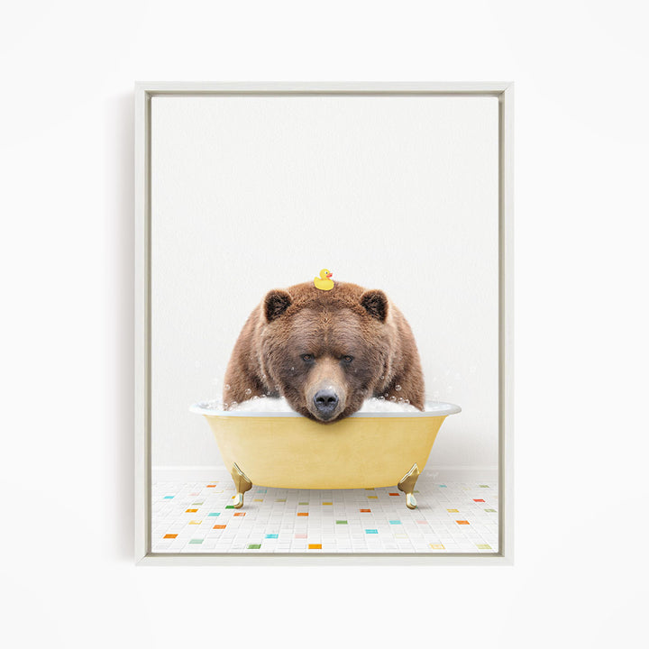 A brown bear is sitting in a yellow bathtub, with a rubber duck floating on its head.