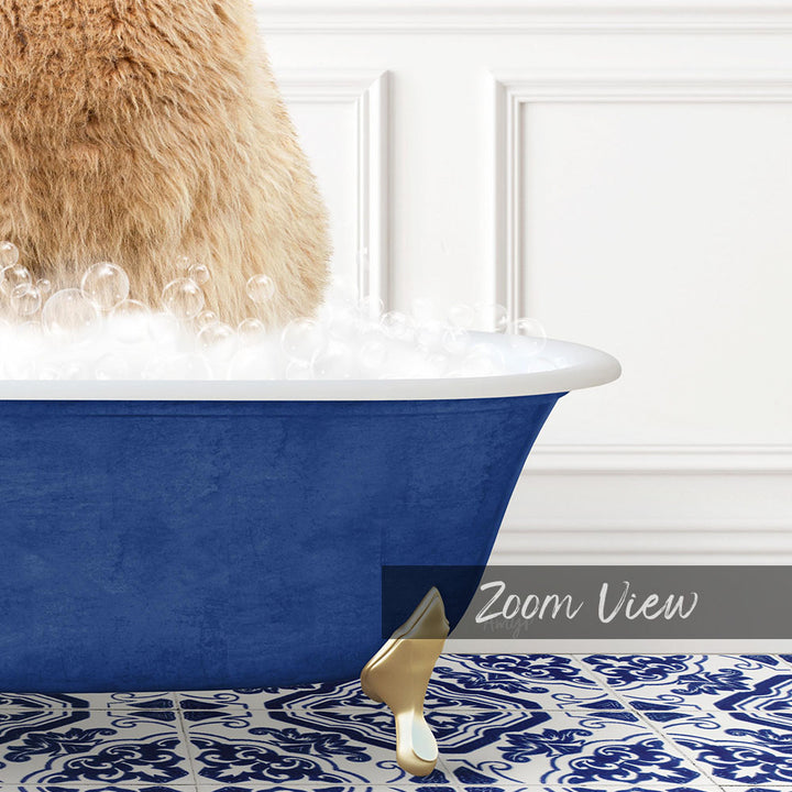 A fluffy brown cat is sitting in a blue bathtub filled with bubbles, with a gold faucet and a white wall in the background.