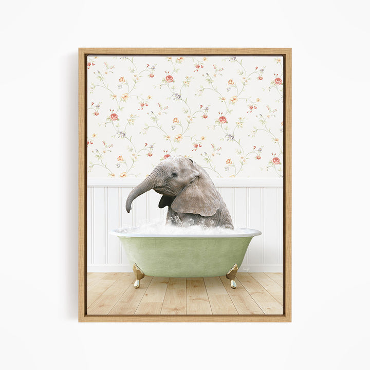A baby elephant sitting in a green bathtub filled with water, surrounded by a floral wallpaper.