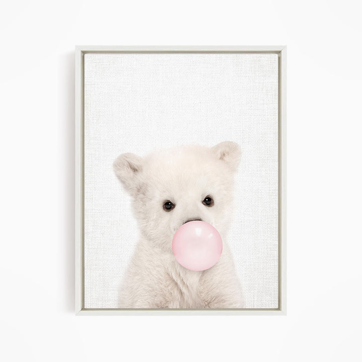 A cute white polar bear is blowing a bubble with a pink bubble gum bubble.