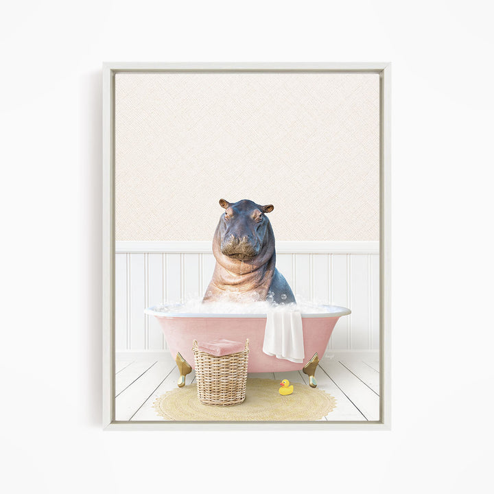 A hippopotamus sitting in a pink bathtub filled with water, surrounded by a yellow rubber duck and a wicker basket.