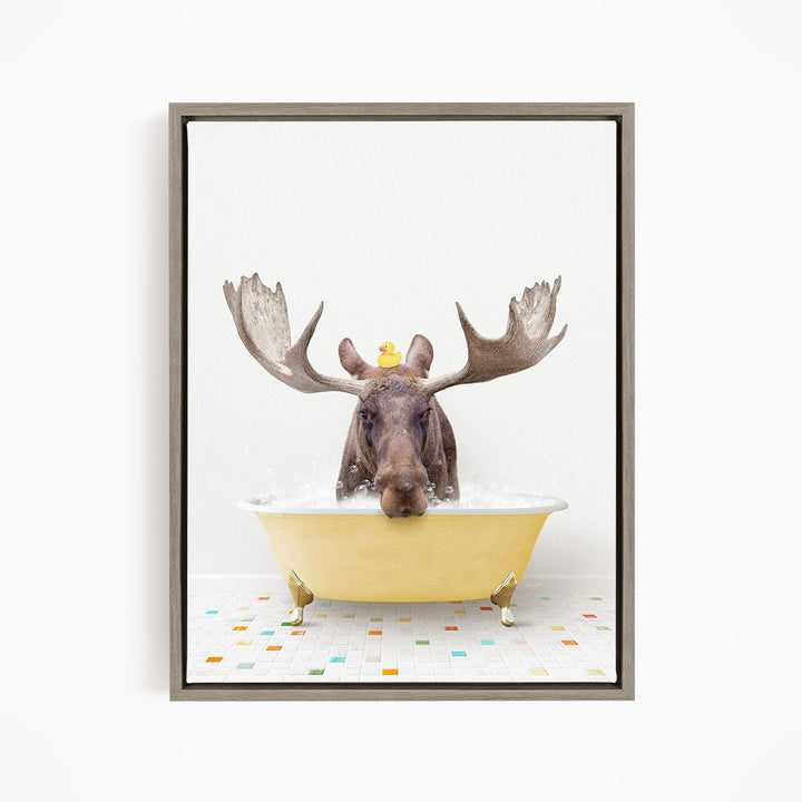 A moose with large antlers is sitting in a yellow bathtub, with a rubber duck floating on its head.