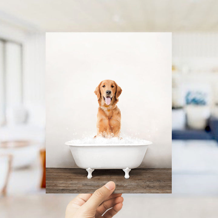 A golden retriever dog sitting in a white bathtub filled with water, with bubbles around it, and a person's hand holding the photo up to the camera.