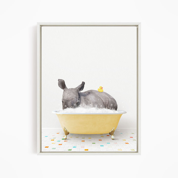A rhinoceros is sitting in a yellow bathtub filled with bubbles, with a yellow rubber duck floating on its back.
