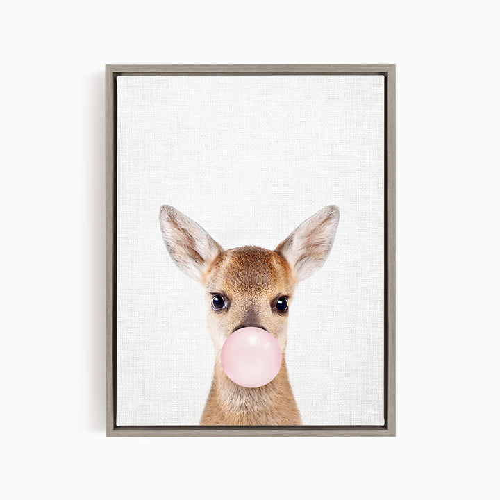 A deer with large ears blowing a pink bubblegum bubble.