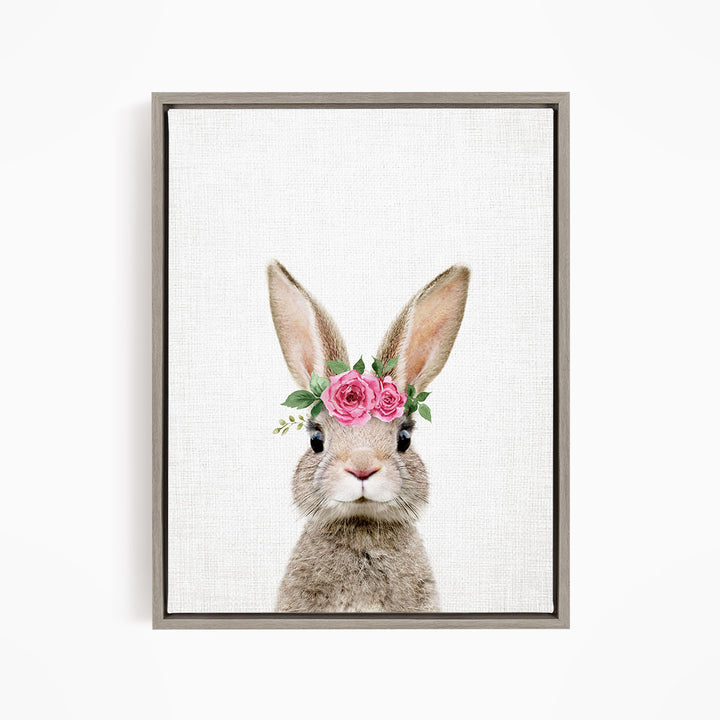 A cute rabbit wearing a pink flower crown on its head, looking directly at the camera.