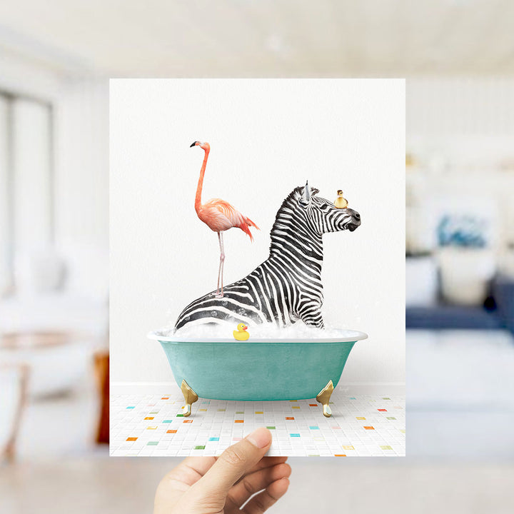 A hand holds up a collage of two images: a zebra standing in a bathtub with a pink flamingo, and a yellow rubber duck floating in the water.