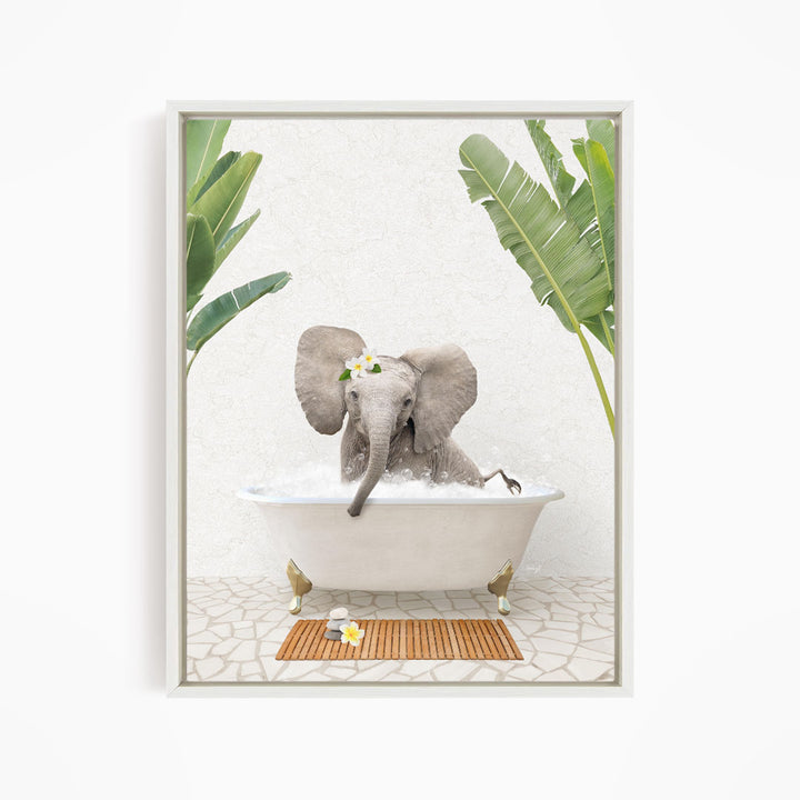 A gray elephant is sitting in a white bathtub filled with water, surrounded by green leaves and a wooden mat on the floor.