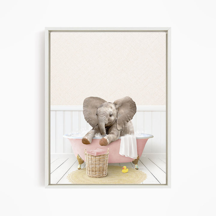 A baby elephant sitting in a pink bathtub, surrounded by a yellow rubber duck and a basket.