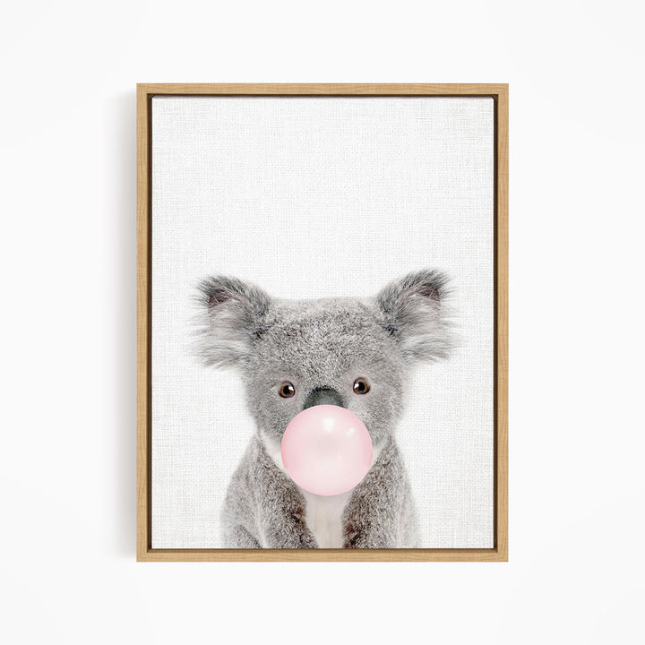 A cute koala bear blowing a bubble with a pink bubble gum bubble.