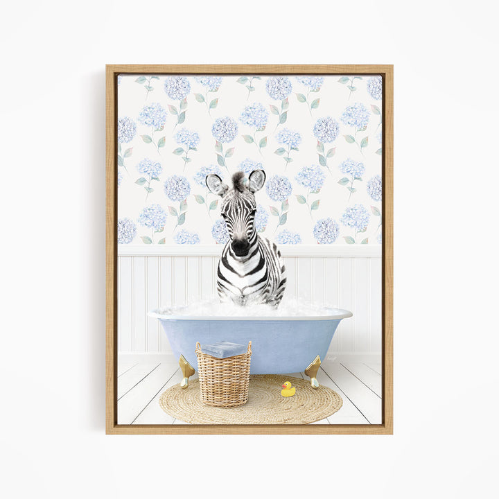 A zebra sitting in a blue bathtub filled with water, surrounded by a wicker basket and rubber duckies.