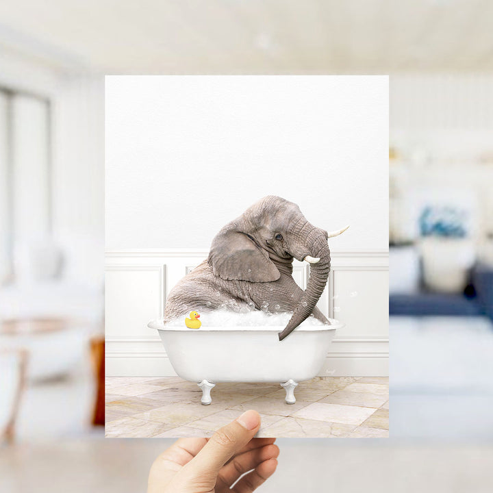A gray elephant sitting in a white bathtub filled with water and bubbles, with a yellow rubber duck floating nearby.
