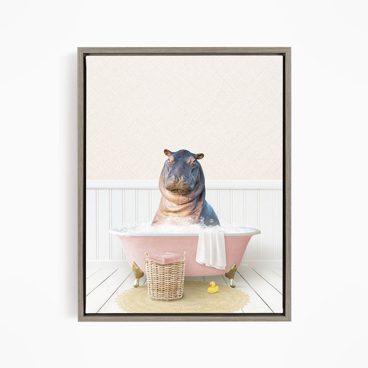 A hippopotamus sitting in a pink bathtub filled with water, surrounded by a yellow rubber duck and a basket.