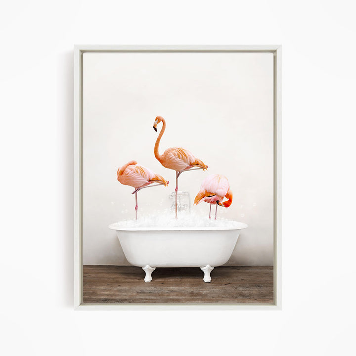 A framed image depicting three flamingos standing in a white bathtub filled with water, creating a whimsical and playful scene.