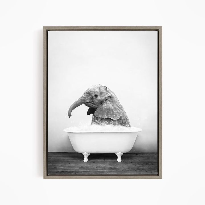 A baby elephant sitting in a bathtub filled with water, appearing to enjoy the bath.