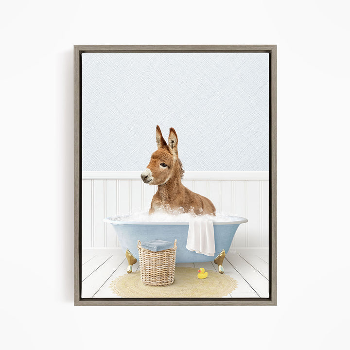 A donkey is sitting in a blue bathtub filled with water, surrounded by a basket of toys and a yellow rubber duck.