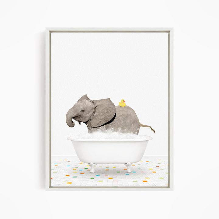 A gray elephant is standing in a white bathtub filled with bubbles, with a yellow rubber duck perched on its back.