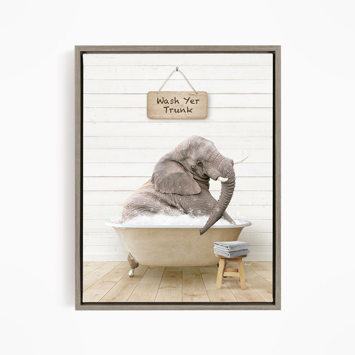 A gray elephant sitting in a bathtub, with a wooden sign above it that says "Wash Yer Trunk".