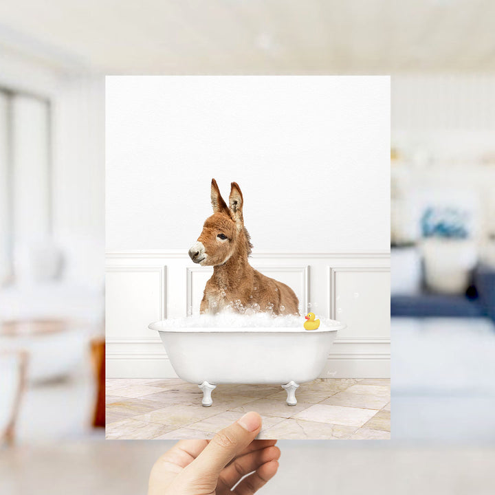 A donkey is sitting in a bathtub filled with bubbles, with a rubber duck floating in the water.