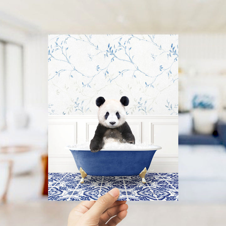 A panda bear sitting in a blue bathtub, surrounded by a floral patterned wall.