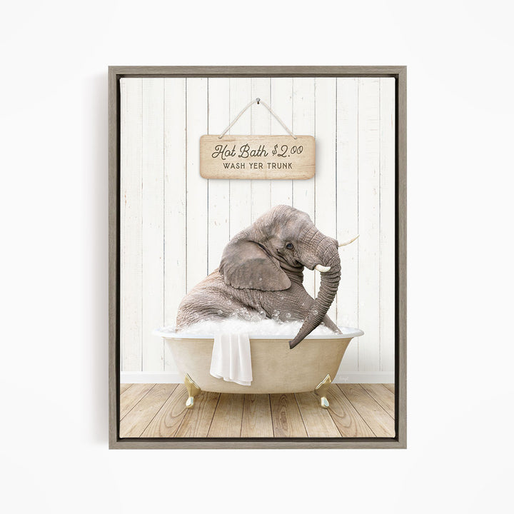 A gray elephant is sitting in a white bathtub, with a wooden sign above it that reads "Hot Bath $2.00 WASH YER TRUNK".