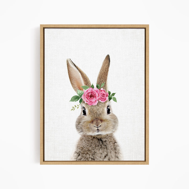 A cute rabbit wearing a floral crown of pink roses and greenery.