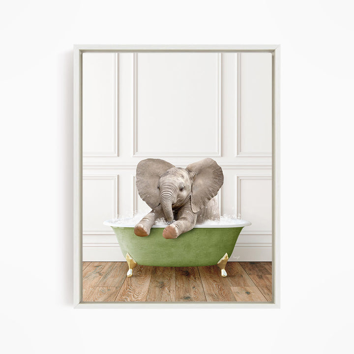 A baby elephant sitting in a green bathtub filled with water, with its trunk raised and ears spread out.