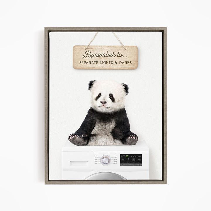 A panda bear sitting on top of a washing machine, with a wooden sign above that says "Remember to separate lights & darks".
