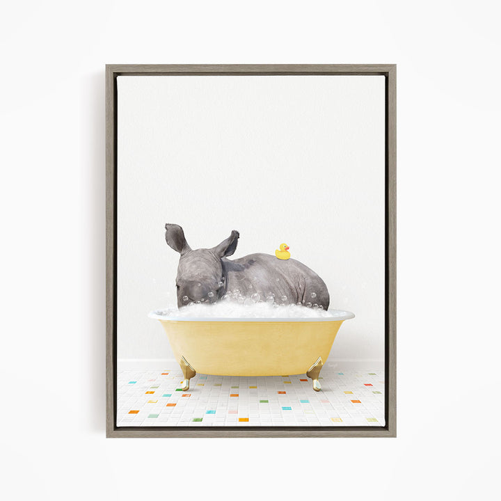 A rhinoceros is sitting in a yellow bathtub filled with bubbles, with a yellow rubber duck floating on its back.
