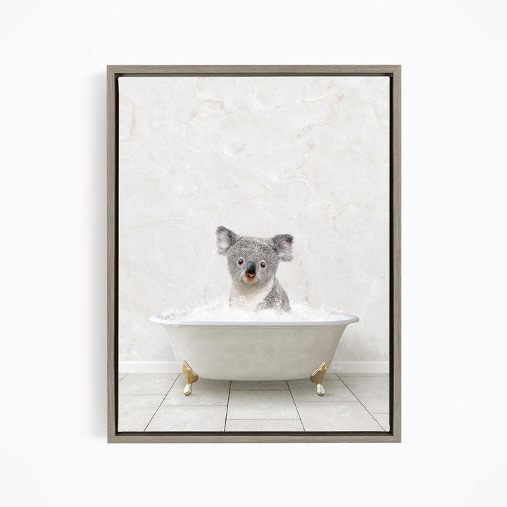 A koala bear sitting in a white bathtub filled with water, looking directly at the camera.
