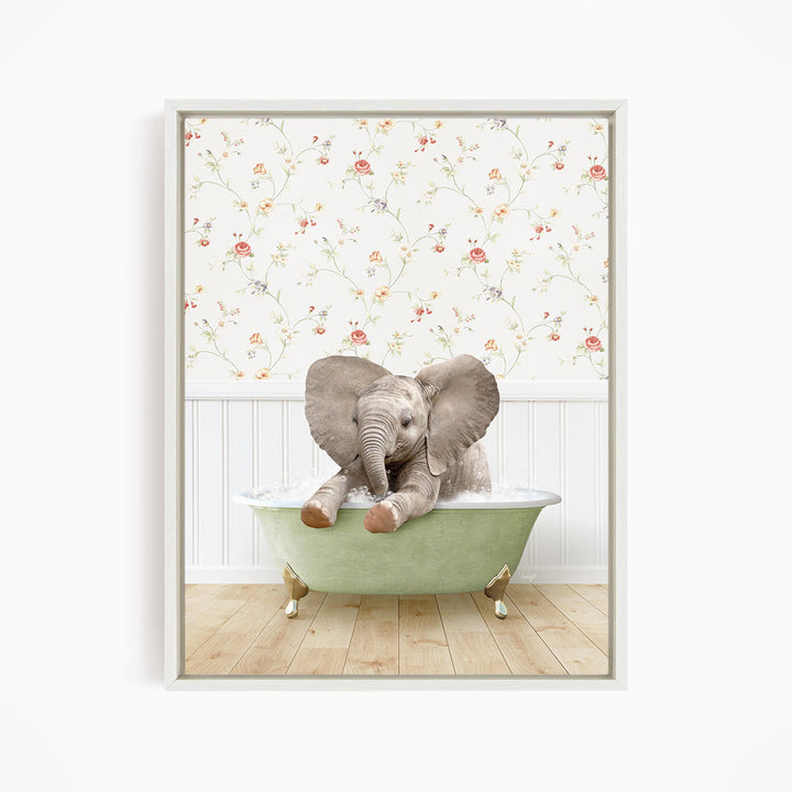 A baby elephant sitting in a green bathtub, with its trunk raised and ears spread, against a floral wallpaper background.