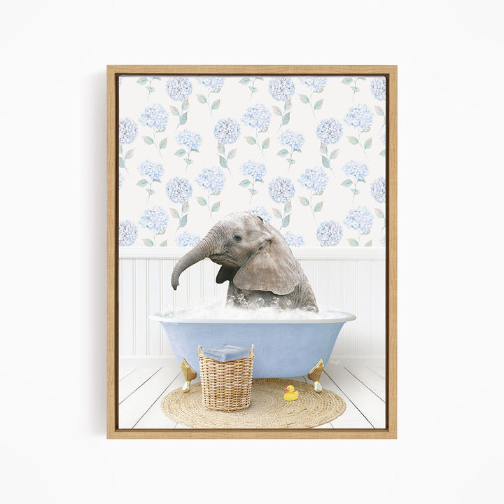 A baby elephant sitting in a blue bathtub filled with water, surrounded by a wicker basket and yellow rubber ducks.
