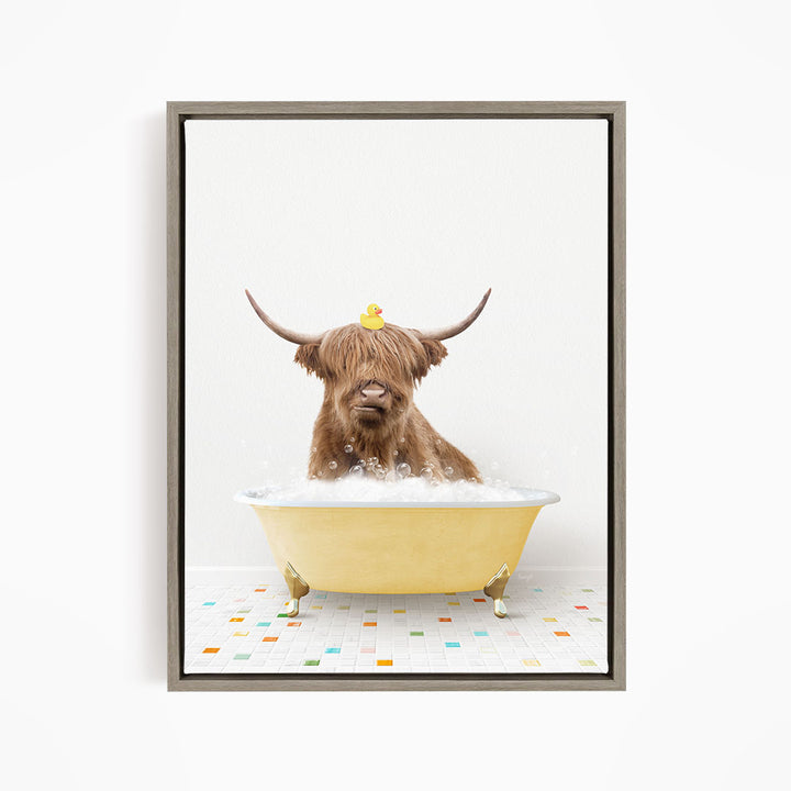A Highland cow with large horns is sitting in a yellow bathtub filled with bubbles, with a rubber duck perched on its head.
