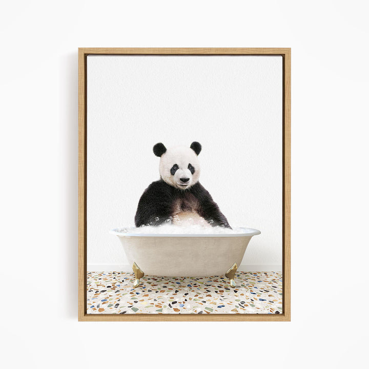 A panda bear sitting in a white bathtub filled with bubbles, looking directly at the camera.