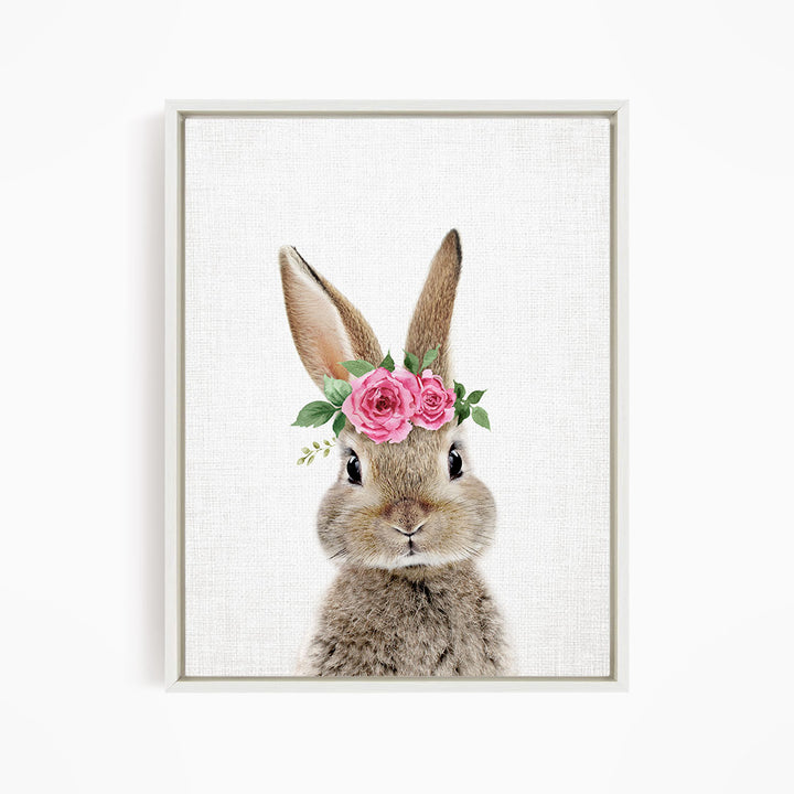 A cute bunny wearing a floral crown of pink roses and greenery.
