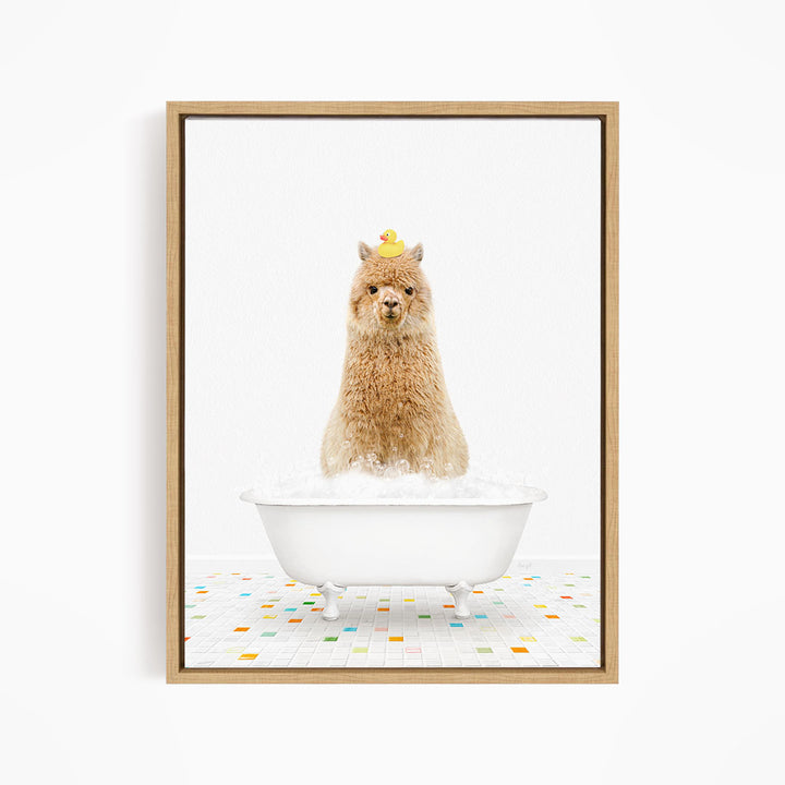 A fluffy brown llama sits in a white bathtub filled with bubbles, with a yellow rubber duck perched on its head.