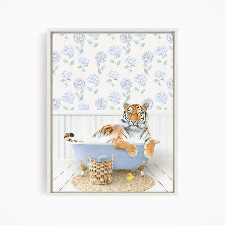 A tiger is sitting in a bathtub filled with water, surrounded by a blue and white floral patterned wall and a basket of rubber ducks.