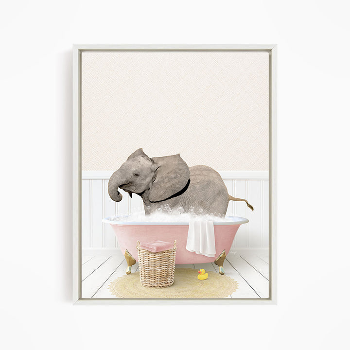 A gray elephant is sitting in a pink bathtub filled with water, surrounded by a yellow rubber duck and a basket.