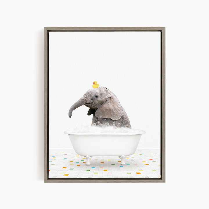 A baby elephant sitting in a white bathtub, with a yellow rubber duck perched on its head.