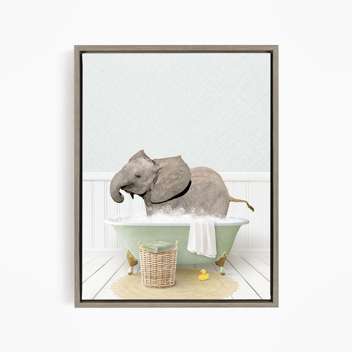 A gray elephant is sitting in a green bathtub filled with water, surrounded by a basket of toys and a yellow rubber ducky.