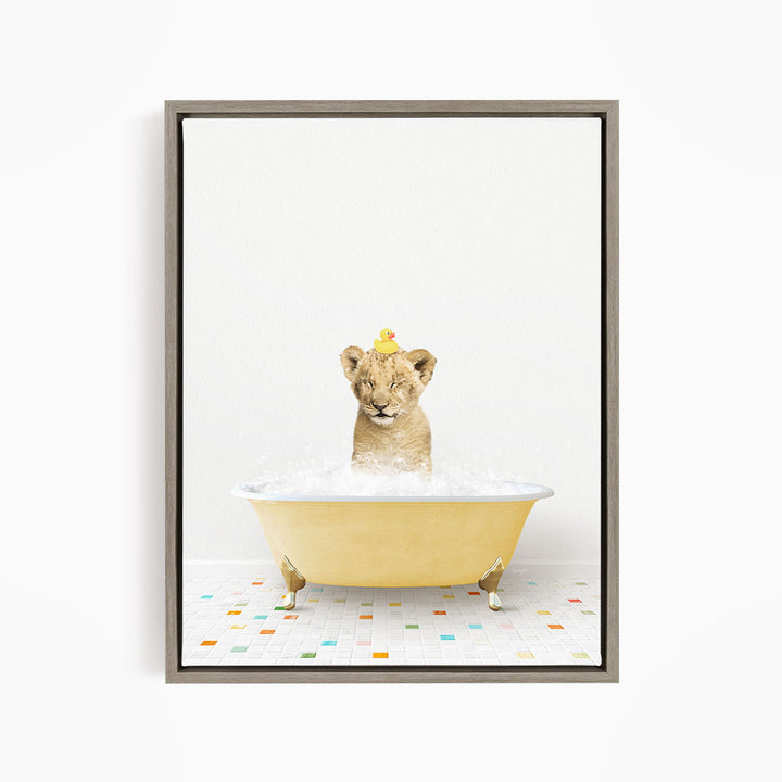 A young lion cub sitting in a yellow bathtub filled with bubbles, with a rubber duck perched on its head.