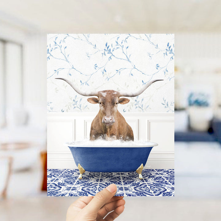 A brown bull with long horns is sitting in a blue bathtub filled with water, creating a whimsical and humorous scene.