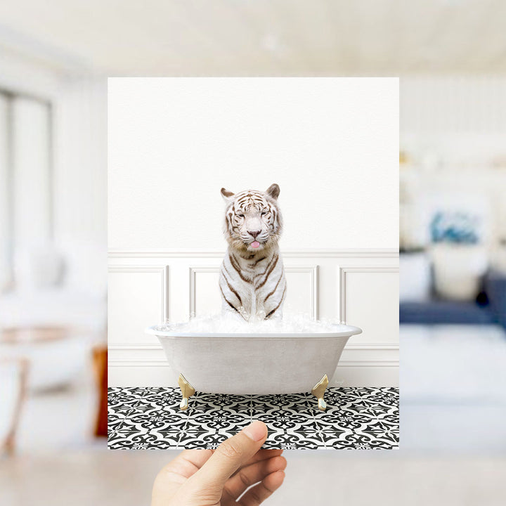 A white tiger sitting in a white bathtub filled with water, with a hand holding the image up to the viewer.