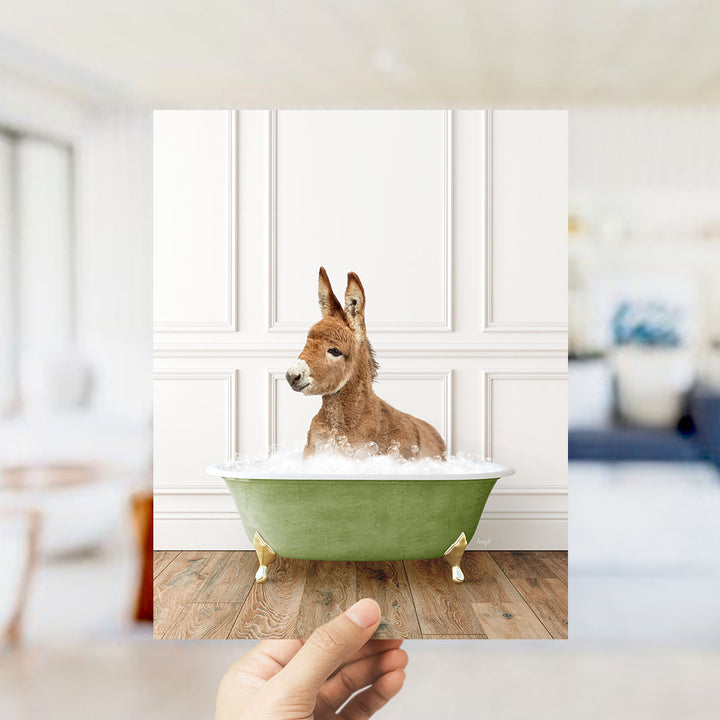 A donkey sitting in a green bathtub filled with bubbles, with a blurred background suggesting a living room setting.